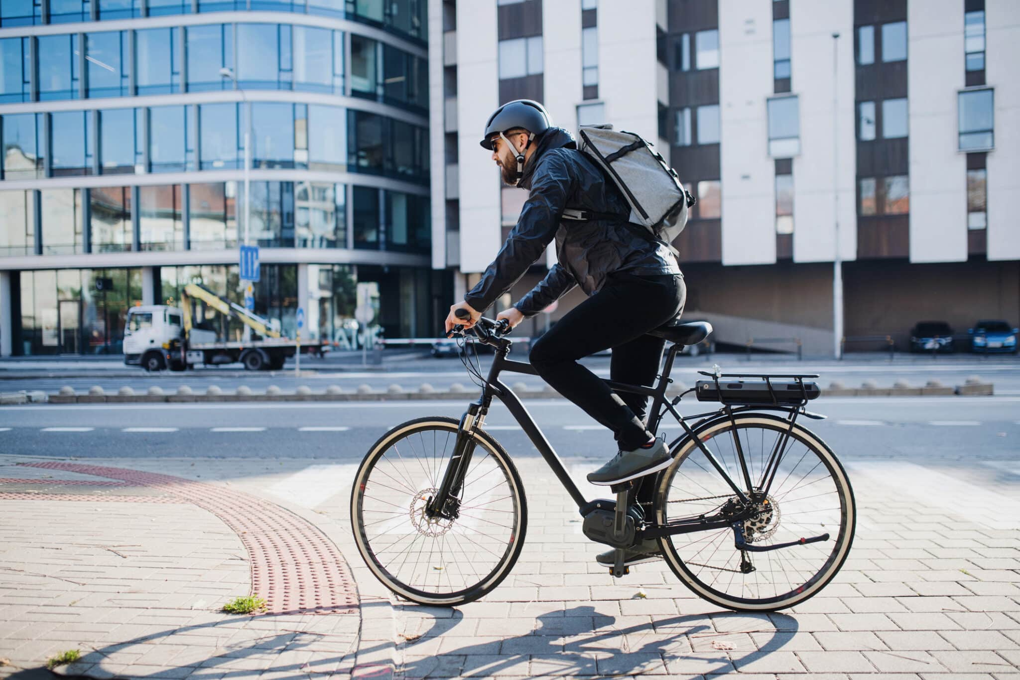 male courier with bicycle delivering packages in city. copy space.